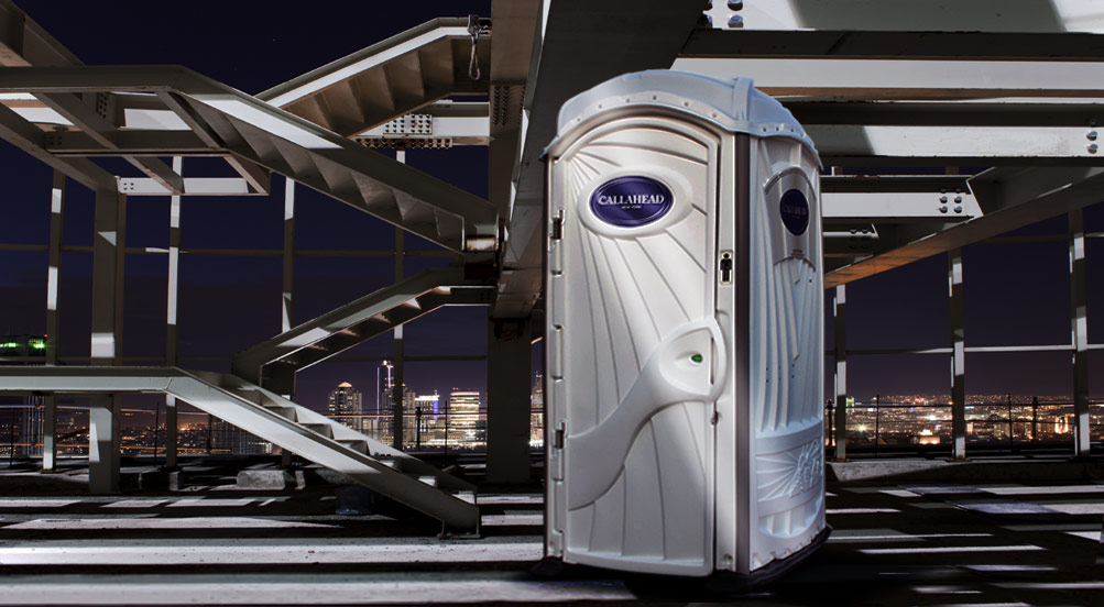 A White Toilet Portable Restroom At A Building Site