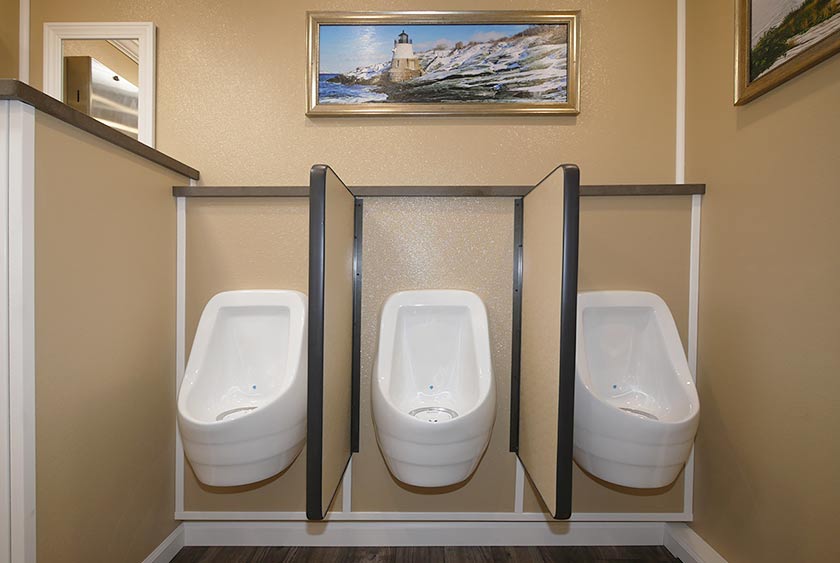 THREE SLOAN PORCELAIN WATERLESS URINALS WITH PRIVACY DIVIDERS AND A CONVENIENCE SHELF ABOVE