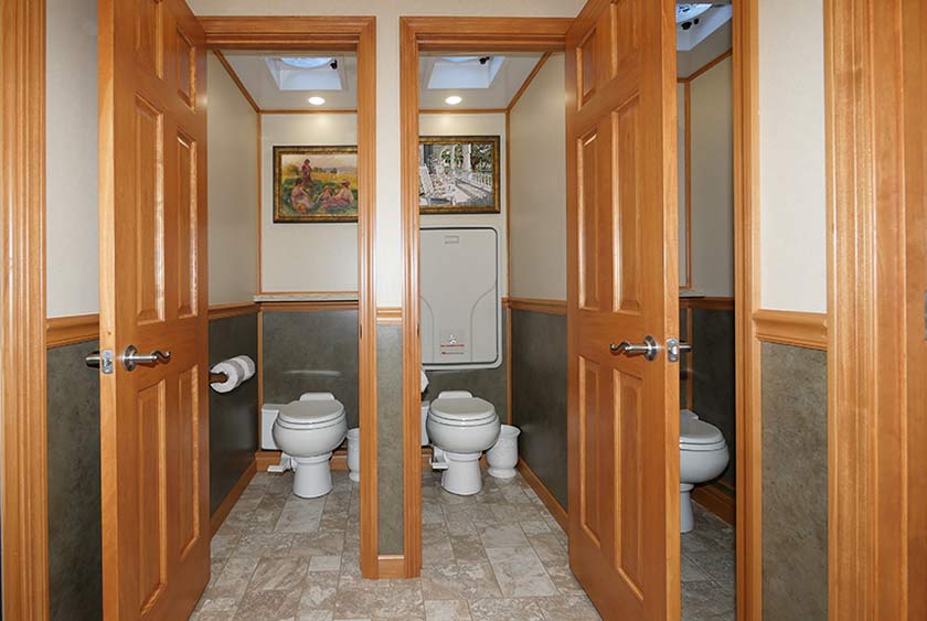 FULLY ENCLOSED BATHROOM STALLS WITH FLOOR TO CEILING LOCKABLE WOOD DOORS FOR COMPLETE PRIVACY