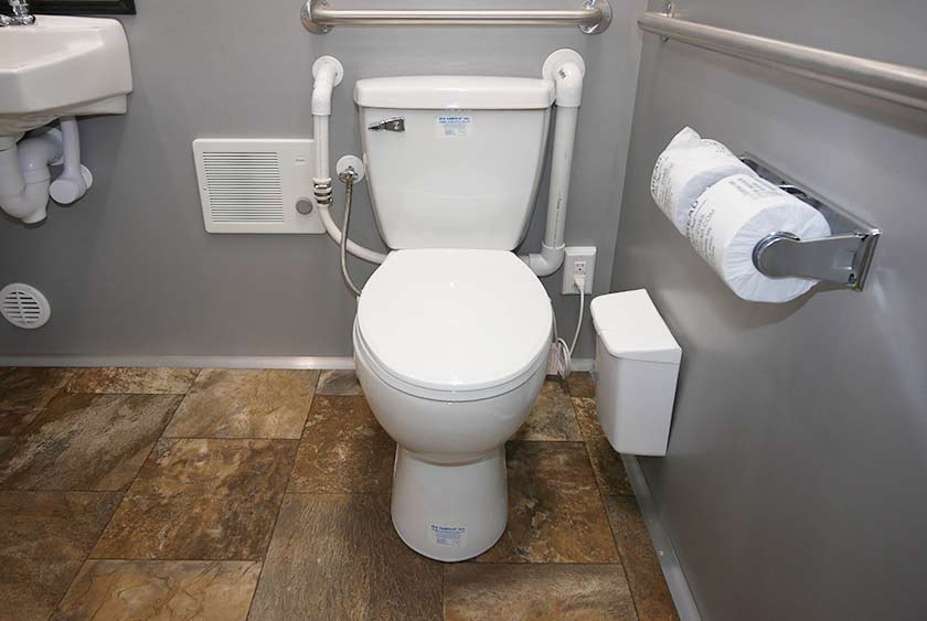 FULL SIZED PORCELAIN TOILETS WITH SAFETY GRAB BARS ON TWO SIDES