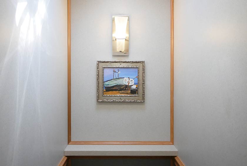 LIGHTED SCONCES WITH ARTWORK INSIDE EACH BATHROOM STALL