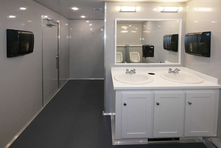 VANITY AREA ON MEN'S SIDE INCLUDES TWO SINKS AND LARGE MIRROR WITH DOUBLE SCONCE LIGHTING