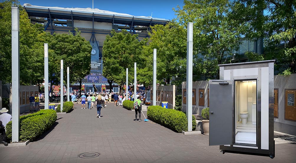 White Wash Portable Restroom  | Black White Wash Portable Restroom Inside a Factory with Large Duct Pipes Throughout.