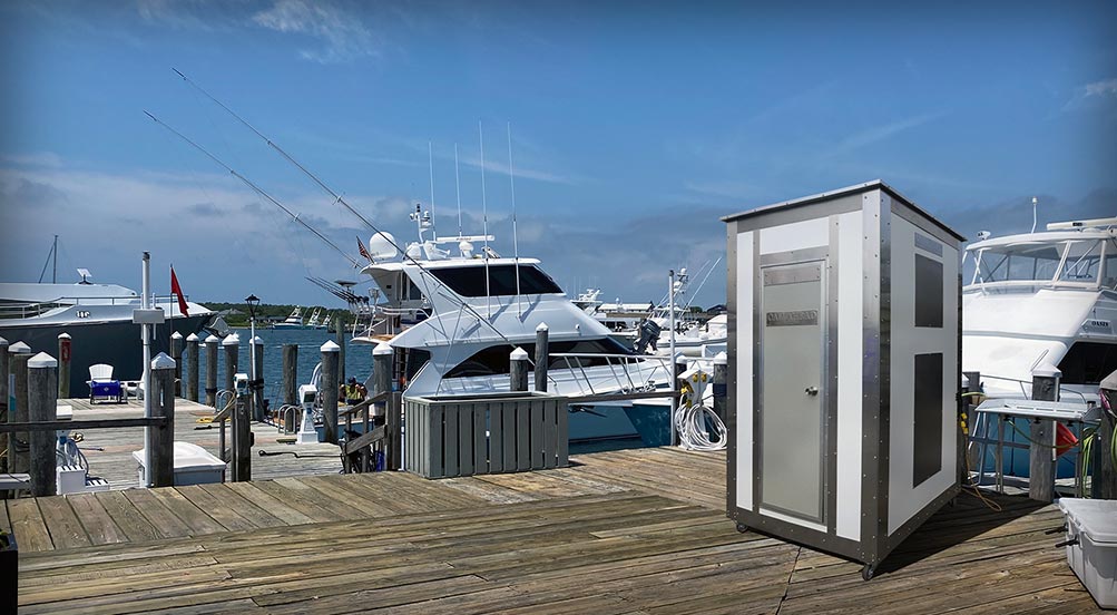 White Wash Portable Restroom | Yellow Colored White Wash Portable Restroom Outdoors at a Construction Site with a Crane in the Background