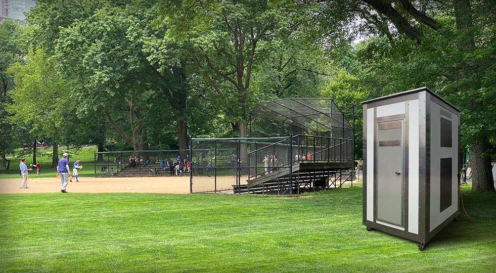 White Wash Portable Restroom | Orange Colored White Wash Portable Restroom Being Hoisted by a Crane to a Jobsite